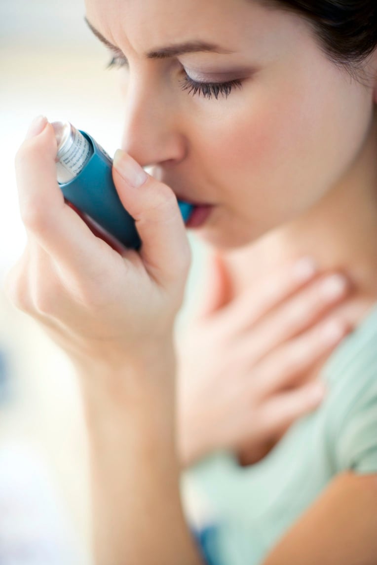 ^BMODEL RELEASED^b.^B Asthma inhaler use.^b Woman using an inhaler to treat an asthma attack.